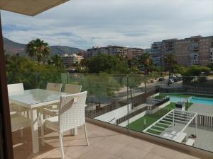 a balcony with a table and chairs and a view of a city at Residencial El Trenet 2C in Benicàssim