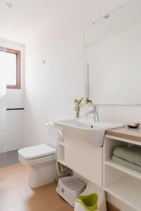 Baño blanco con lavabo y aseo en La Figuera, en Ultramort