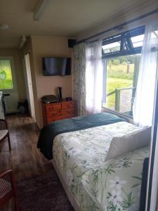 Un dormitorio con una cama grande y una ventana en Peaceful ensuite lakeside cabin 'Tench' en Hadlow Down