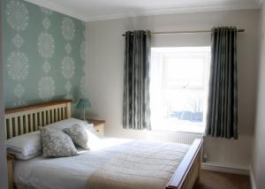 a bedroom with a bed and a window with curtains at Roundstone House Hotel in Roundstone