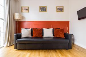 a black couch with pillows on it in a living room at Beautiful Euston in London