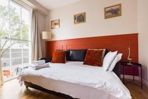 a bedroom with a large bed and a large window at Beautiful Euston in London