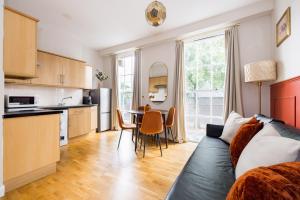a kitchen and living room with a couch and a table at Beautiful Euston in London