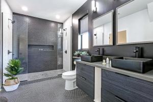 un bagno con due lavandini, un water e una doccia di 5 bedroom Villa w private rooftop a New Orleans