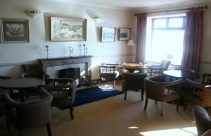 a dining room with tables and chairs and a fireplace at Roundstone House Hotel in Roundstone