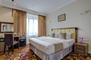 a hotel room with a large bed and a desk at Garden Hotel & SPA in Bishkek +62 photos