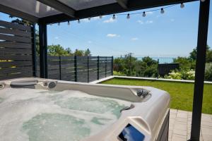 a jacuzzi tub on a patio with a view at Lake Spirit Boutique Apartments in Balatonalmádi