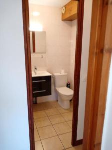 a bathroom with a white toilet and a sink at La Chamade in Le Biot