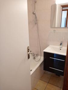 a white bathroom with a sink and a shower at La Chamade in Le Biot