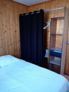a bedroom with a bed and a black curtain and a ladder at La Chamade in Le Biot