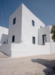 a white building with windows on the side of it at Traditional White House in Dhragoulás