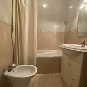 a bathroom with a sink and a toilet and a bath tub at Apartamento Varanda do Sol in Amora +33 photos