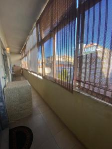 um quarto com grandes janelas com uma cadeira e uma vista em Apartamento Varanda do Sol em Amora