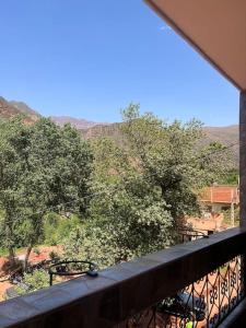 een balkon met uitzicht op bomen en bergen bij Appartement avec belle vue à ourika Oulmes in Marrakesh