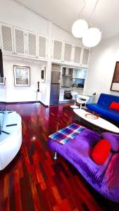 カラカスにあるLoft de lujo ubicado en zona inmejorable Altamiraの紫色のソファとテーブル付きのリビングルーム