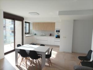 a kitchen and dining room with a table and chairs at Residencial El Trenet Ático-Duplex in Benicàssim