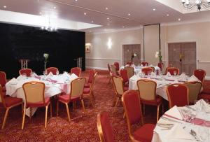 a conference room with tables and chairs and a projection screen at Holiday Inn Reading West, an IHG Hotel in Reading