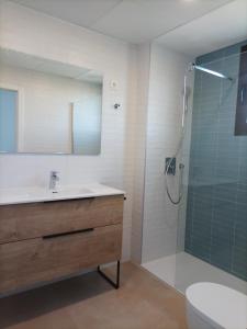 La salle de bains est pourvue d'un lavabo et d'une douche en verre. dans l'établissement Residencial El Trenet Ático-Duplex, à Benicàssim