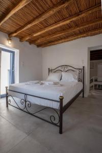 a bed in a white room with a wooden ceiling at Traditional White House in Prodromos Paros