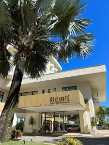 a building with a palm tree in front of it at Hotel Orizzonte Niteroi by Atlantica in Niterói