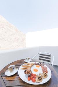 un plato de desayuno en una mesa de madera en Dodomar Selection, en Perissa