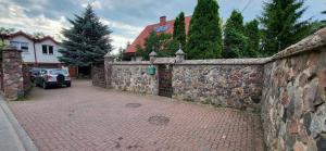 a stone fence and a brick sidewalk in front of a house at Szpitalna 9c in Suwałki