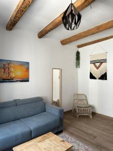 uma sala de estar com um sofá azul e uma cadeira em Coeur Panier - Charmant T2 entièrement équipé em Marselha