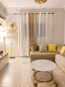 - un salon avec un canapé et une table dans l'établissement Appartement Jnane Awrad, Marrakech, à Marrakech