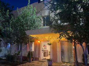 a house with lights on the front of it at night at Koonjak in Bukhara