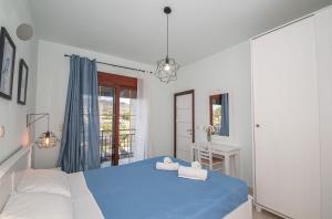 a bedroom with a blue bed and a window at Petra Villas in Gennadi