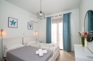 a white bedroom with a bed and a window at Petra Villas in Gennadi