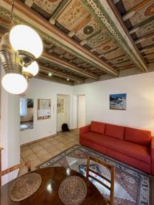 een woonkamer met een rode bank en een tafel bij Mala Strana apartment 1 in Praag