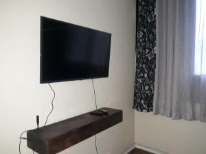 a flat screen tv hanging on a wall at Apartamento Gonzaga in Santos