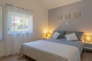 a bedroom with a bed with two pillows and a window at Lovely guest house Veli Vrh in Pula