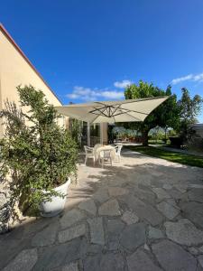 een patio met een tafel en een parasol bij Villa Marina B&B in Savuto