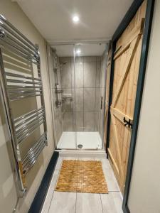 a bathroom with a shower with a glass door at Cherry Cottage 