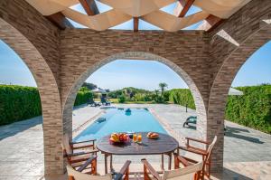 a patio with a table and chairs next to a swimming pool at Petra Villas in Gennadi