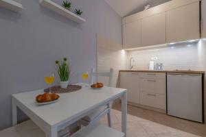 a white kitchen with a table and two glasses of wine at Lovely guest house Veli Vrh in Pula