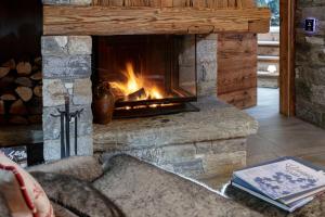 a fireplace in a living room with a fire at Chalet Matterhorn Francois with SPA and Breakfast - 100mt lift in Breuil-Cervinia