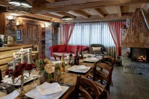 ein Esszimmer mit Tisch und Kamin in der Unterkunft Chalet Matterhorn François - Central Alpine Chalet with Private SPA & Breakfast in Breuil-Cervinia