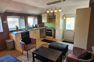 een keuken en een woonkamer met een tafel en stoelen bij The Annexe in Yorkley