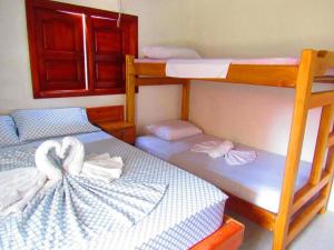 a bedroom with three bunk beds with towels on them at kelly tours in Capurganá