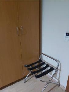 een metalen stoel in een kamer naast een kast bij Apto no hotel Comfort de Taguatinga in João Neiva