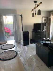 ein Wohnzimmer mit Tisch und Stühlen und einem Fernseher in der Unterkunft gite l'etoile de mer in Eu