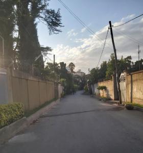 eine leere Straße mit einem Zaun an der Seite in der Unterkunft Comfy House 5 mins to Bole Airport in Addis Abeba