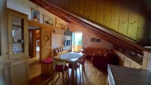 uma sala de estar com uma mesa e um sofá em Deliziosa mansarda con vista Dolomiti em San Vito di Cadore