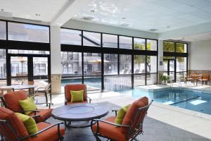 uma piscina com cadeiras, uma mesa e um ecrã em Courtyard by Marriott Dallas Arlington Entertainment District em Arlington