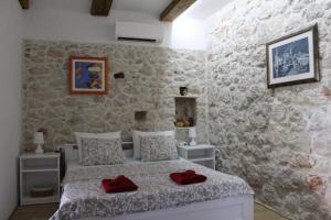 een slaapkamer met een bed met rode kussens erop bij Villa Luca in Grude