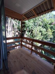a screened in porch with a view of the woods at Castelo de Madeira in Blumenau