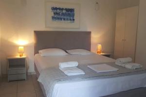 um quarto com uma cama branca e toalhas em Mare Villa Ciel - Private pool - Sea View em Gaios